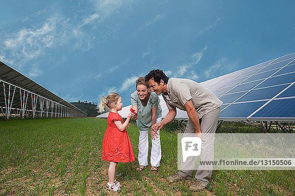 family in front of solar panel