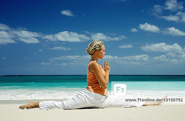 Woman practicing yoga on tropical beach