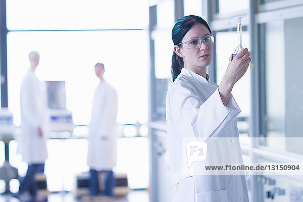 Chemiestudent mit Blick auf den Kolben im Labor