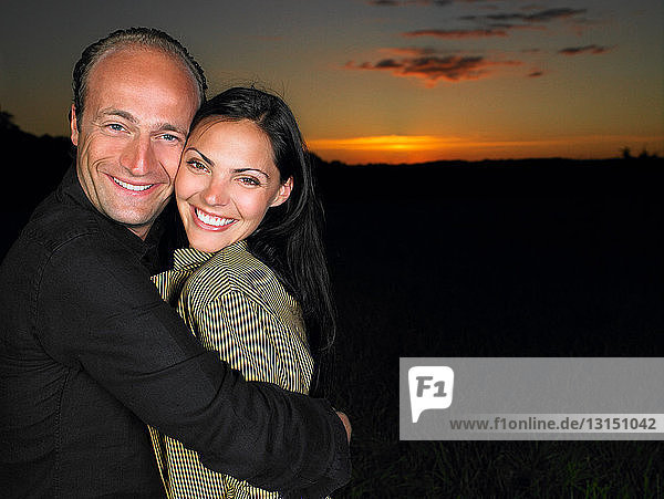Lächelndes Paar auf einem Feld  bei Nacht