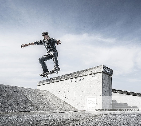 Junger Mann fährt Skateboard auf dem Dach