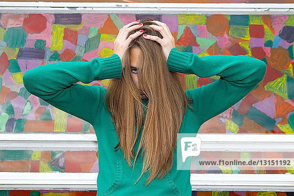 Teenage girl with hands in hair