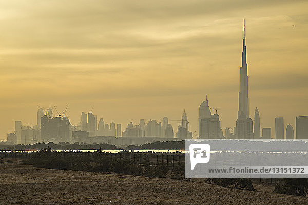 Blick auf den Burj Khalifa und die Skyline der Stadt bei Sonnenaufgang  Dubai