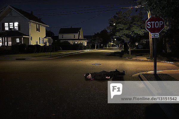 Geschäftsmann liegt nachts bewusstlos auf einer Vorstadtstraße