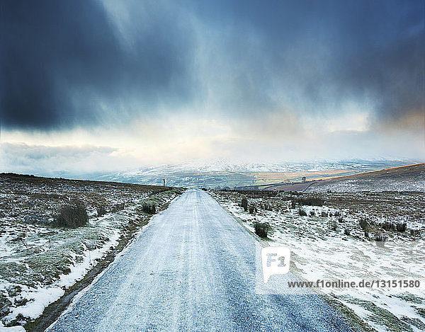 Eisige Landstraße mit Gewitterwolken  Swaledale  Yorkshire  Großbritannien