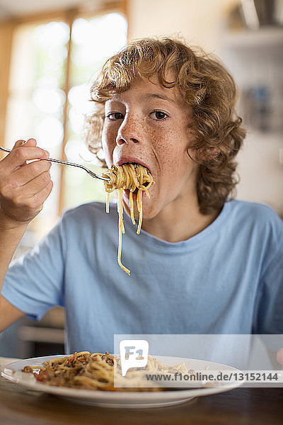 Jugendlicher isst Spaghetti am Esstisch