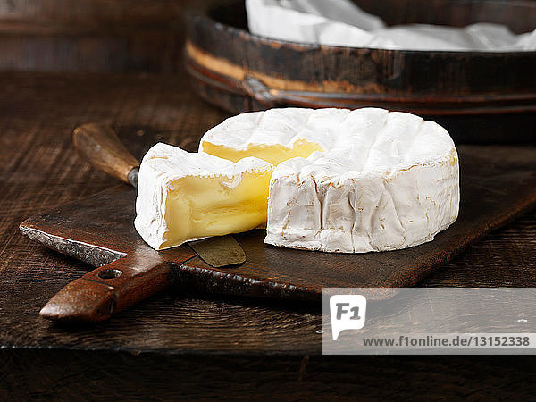 Sliced Camembert cheese on board