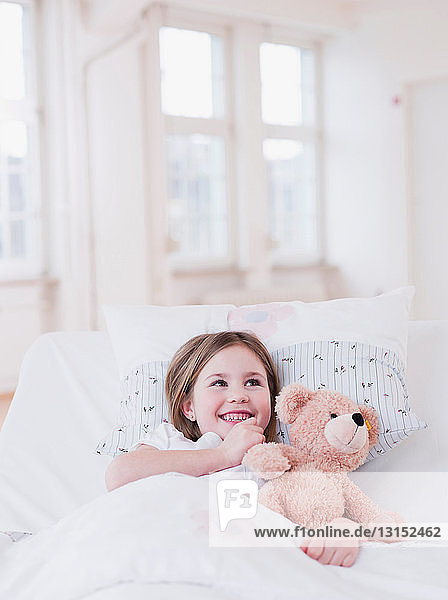 girl in bed with teddy bear