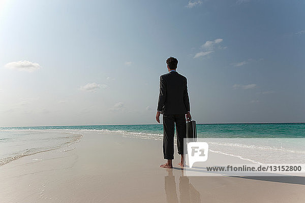 Businessman walking on tropical beach