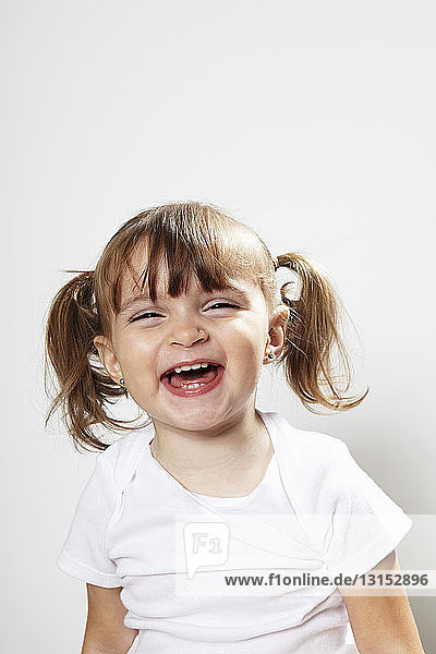 Portrait of young girl with pigtails  laughing