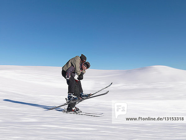 Skifahrer nimmt seinen Freund Huckepack