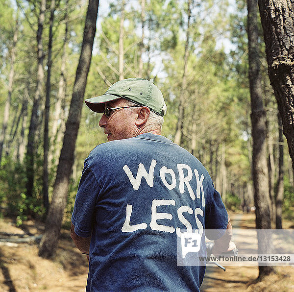 Seniorin im Wald in Work Less-T-Shirt