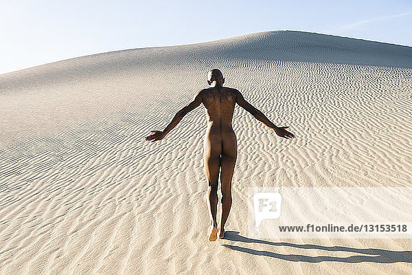 Rückansicht einer nackten Frau in der Wüste
