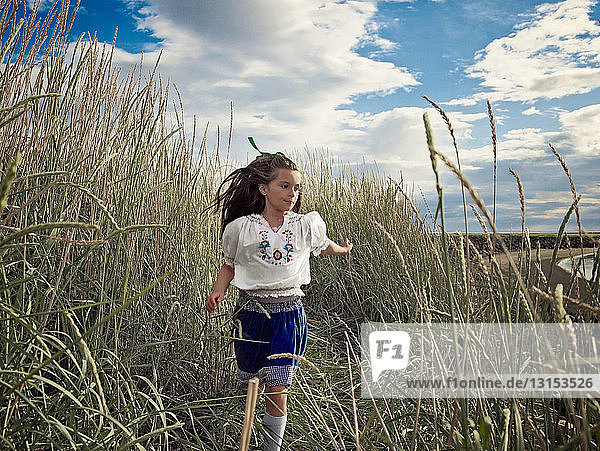 Girl running in wheat field