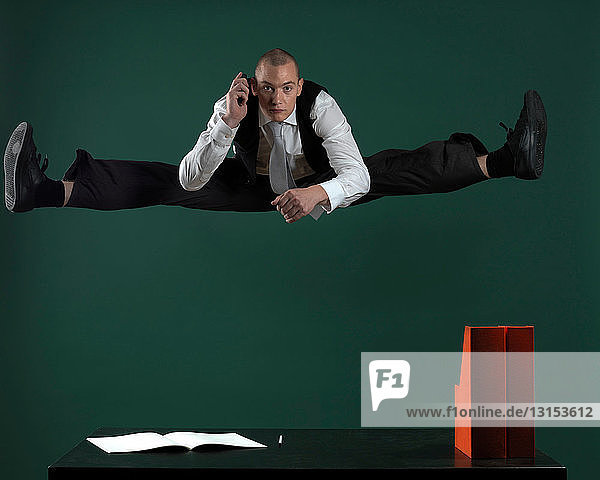 Geschäftsmann springt über Schreibtisch