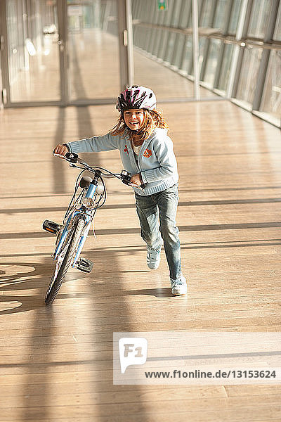 Mädchen geht mit dem Fahrrad durch einen Tunnel in der Stadt