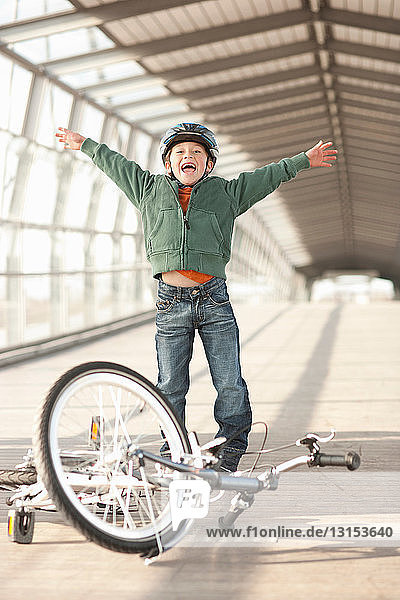 Junge jubelt mit Fahrrad im Tunnel