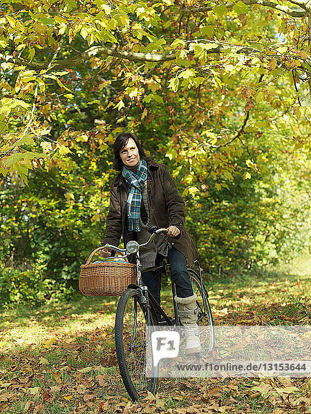 Woman riding bicycle under Autumn trees