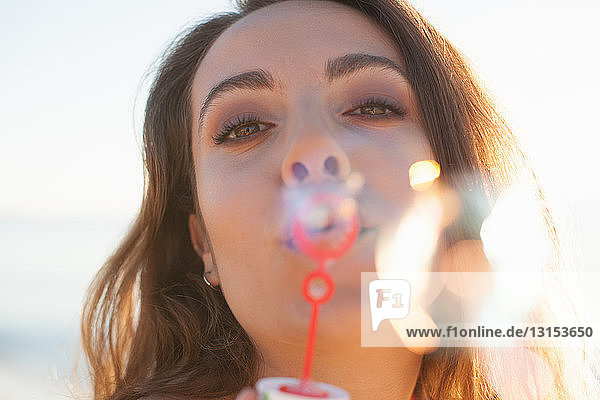 Close up of young woman blowing bubbles on beach  Castiadas  Sardinia  Italy