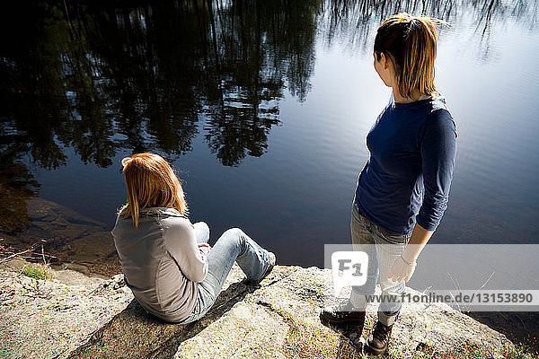 Zwei Frauen schauen auf einen See