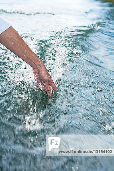 Person  die ihre Hand ins Meerwasser taucht