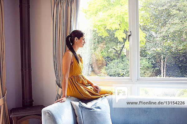 Frau am Fenster sitzend in einem Haus