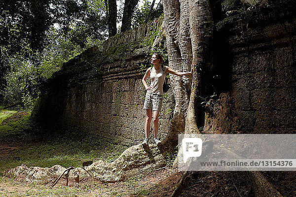 Woman standing on tree roots