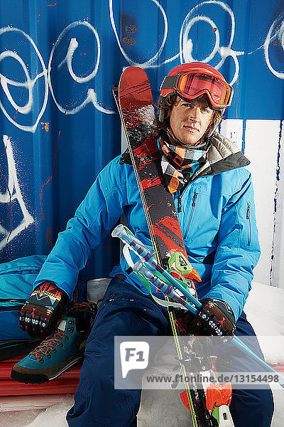 Porträt eines männlichen Skifahrers vor einer Graffitiwand