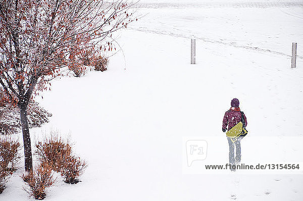 Woman walking in snowy meadow