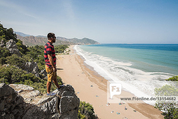 Man on top of cliff looking out over Olympos beach  Lycian way  Turkey