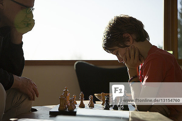 Vater und Sohn spielen eine Partie Schach