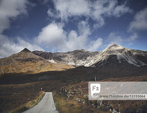 Einspurige Straße durch eine Bergkette  Highland  Schottland