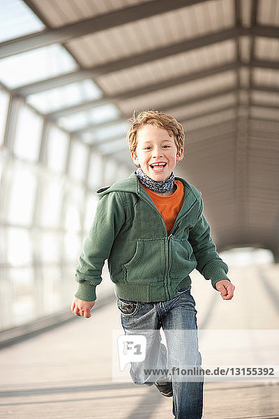Lächelnder Junge läuft in einem Stadttunnel