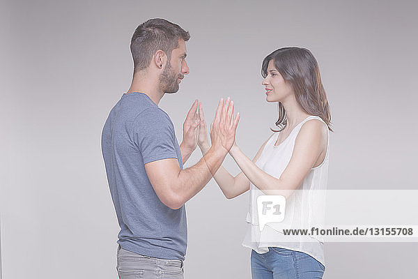 Transparentes Paar  das sich gegenübersteht und die Hände berührt