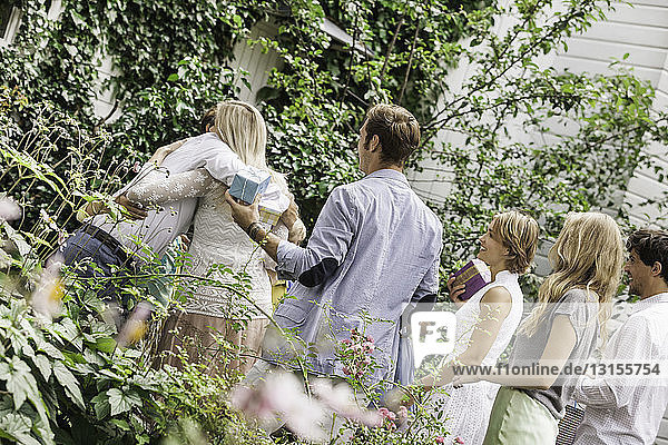 Älteres Paar begrüßt Familie im Garten