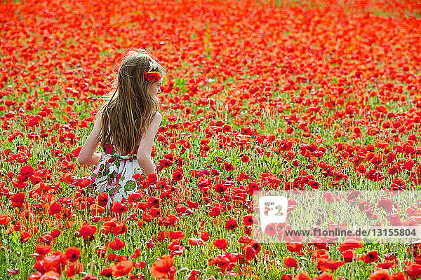 Girl walking in field of flowers