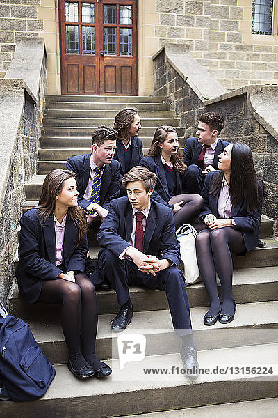 Eine Gruppe von Klassenkameraden entspannt sich auf einer Treppe