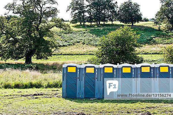 Row of portable toilets in field
