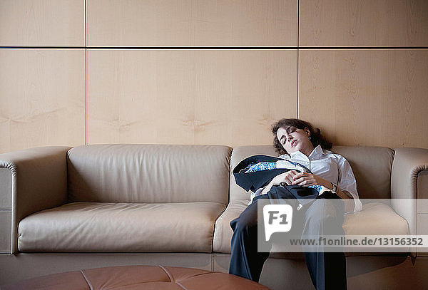 Geschäftsfrau schlafend auf Couch