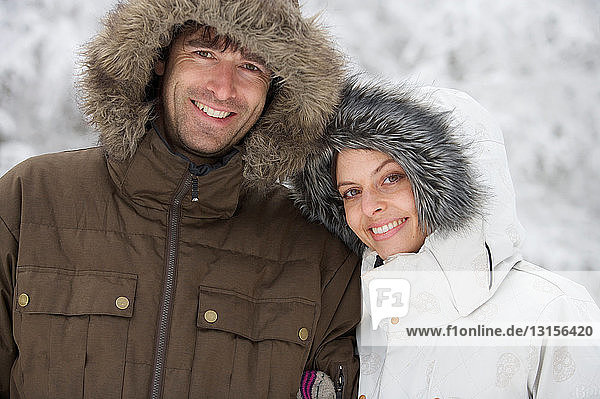 Couple by snow covered trees.