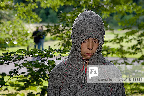 Teenage girl wearing grey hooded top