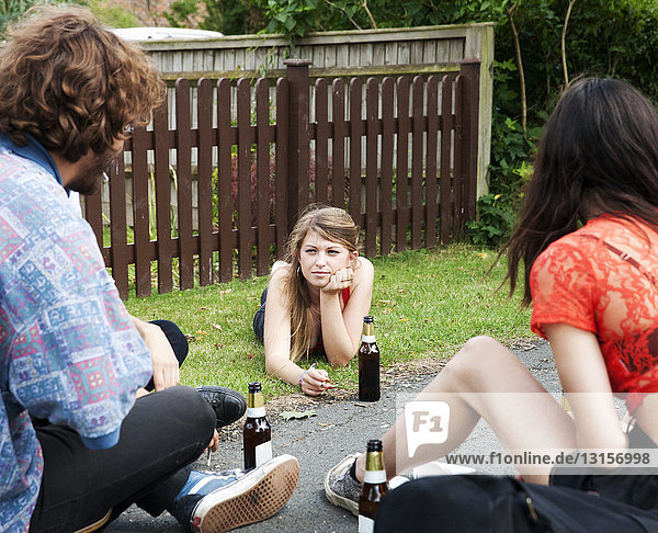 Freunde sitzen im Garten und trinken Bier