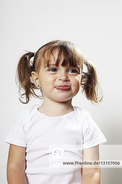 Portrait of young girl with pigtails  making faces