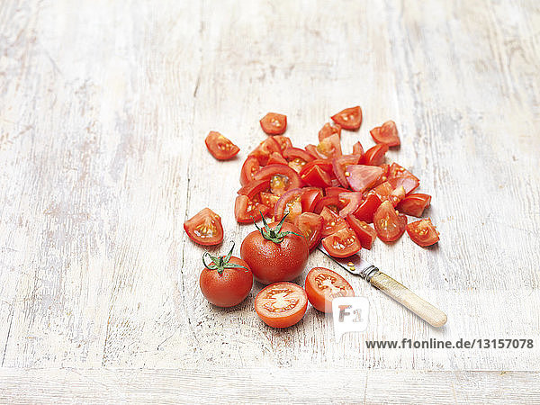 Whole and chopped red juicy sweet tomatoes  knife