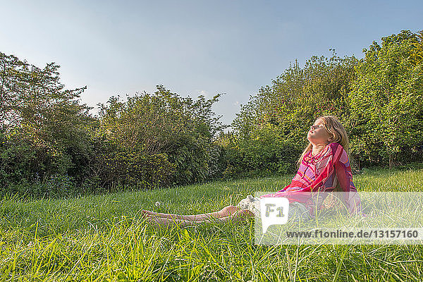Girl sitting in grassy field