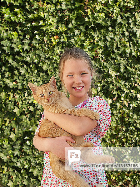 Junges Mädchen hält Katze  lächelnd  Porträt