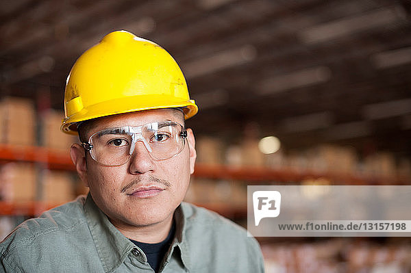 Portrait of mid adult man wearing hard hat and goggles