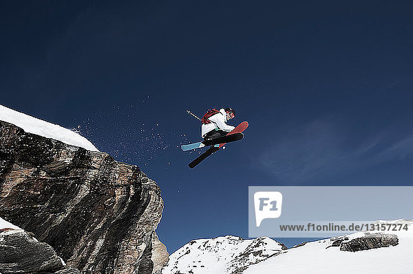 Niedriger Blickwinkel auf einen männlichen Skifahrer in der Luft