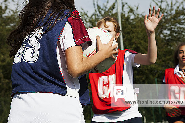 Teenage schoolgirl netball players defending