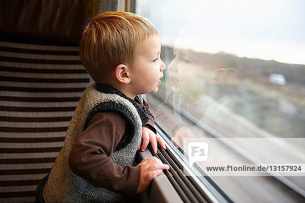 Junger Junge schaut aus dem Zugfenster